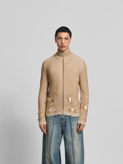 Męski model nosi Slim Fit Jacke im Used-Look od MM6 Maison Margiela, bawełna, imitacja dzianiny, krój slim fit, efekt znoszenia, zamek błyskawiczny dwustronny, długość tyłu w rozmiarze M: 67 cm, szerokość ramion w rozmiarze M: 47 cm, długość rękawów w rozmiarze M: 70 cm, beżowa, widok całego ciała z przodu