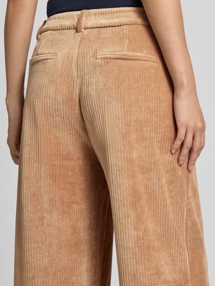 Vrouwenmodel draagt corduroy broek van katoenmix met stretch, relaxed fit, paspelzakken achter, Model 'TAMARY' van ICHI, detailopname rugaanzicht. Context: Dames corduroy broek van ICHI, katoenmix met stretch, relaxed fit, Model 'TAMARY', knoop- en ritssluiting, paspelzakken achter, bandwijdte maat S: 40 cm, binnenbeenlengte maat S: 80 cm.