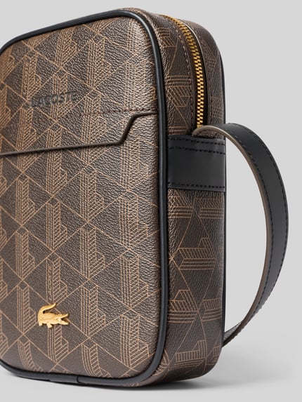 Produktfoto, Umhängetasche mit Logo-Print Modell 'Blend Vertical Camera Bag' von Lacoste für Herren, braun-schwarze geometrische Muster, strukturierte Oberfläche, goldfarbener Reißverschluss, Nahaufnahme, Herren Umhängetasche von Lacoste