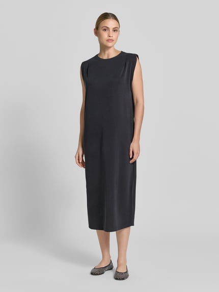 Frauenmodel trägt Midikleid aus Modal-Mix mit Rundhalsausschnitt von Jake*s Collection in Schwarz, gerader Schnitt, seitlicher Schlitz, Ganzkörperansicht von vorne.
