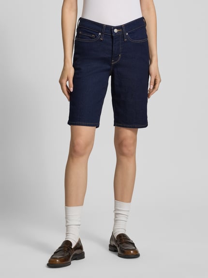 Frauenmodel trägt Bermuda mit 5-Pocket-Design von Levi's® 300 in dunkelblauer Denim-Optik, Slim-Fit Passform, Baumwoll-Mix, Ganzkörperansicht von vorne.