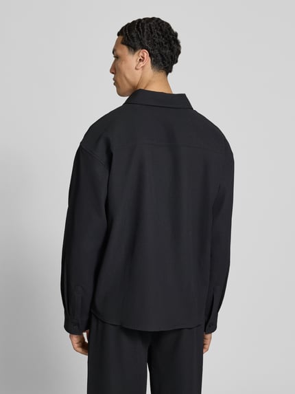 Männermodel trägt Regular Fit Freizeithemd mit Kentkragen und Label-Stitching von Pegador, Material-Mix mit Stretch-Anteil, Ganzkörperansicht Rückansicht.