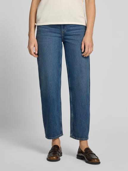 Frauenmodel trägt blaue Straight Fit Jeans aus reiner Baumwolle Modell 'BET' von MANGO, 5-Pocket-Design, Nahaufnahme Unterkörper.