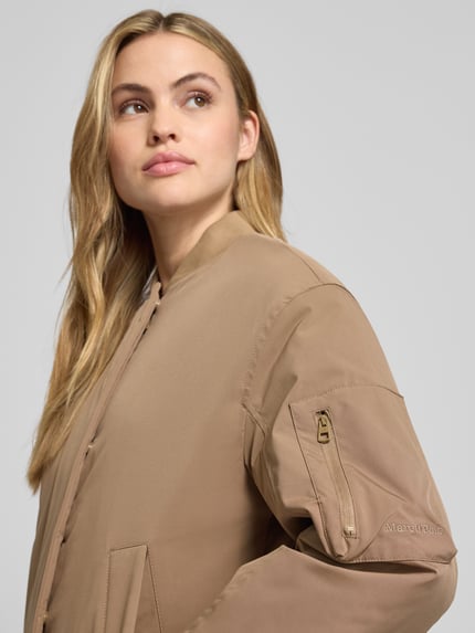 Kobiece modelka nosi Regular Fit Parka mit College-Kragen od Marc O'Polo, beżowy kolor, delikatna faktura, detal rękawa, zbliżenie górnej części ciała.