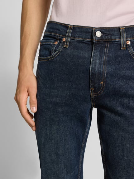 Mannenmodel draagt Slim Fit Jeans uit katoenmix model '511™' van Levi's®, donkerblauw, 5-pocket, detailopname taille en bovenbeen.