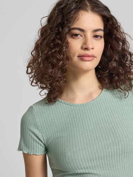 Frauenmodel trägt Slim Fit T-Shirt mit Viskose-Anteil Modell 'EMMA' von Only, Optik: Unifarben, gestreifte Struktur, Nahaufnahme Oberkörper.