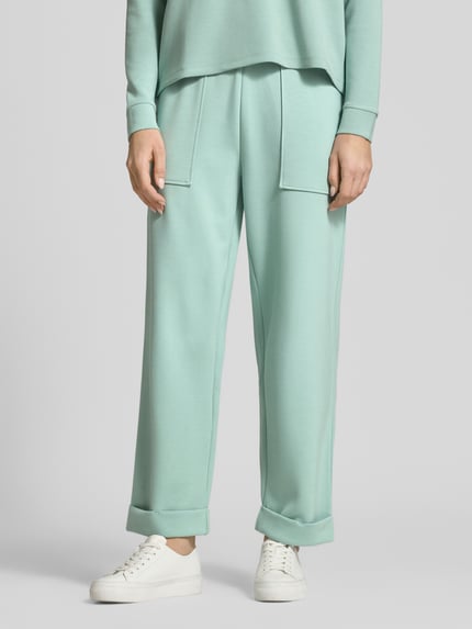 Frauenmodel trägt Sweatpants mit Eingrifftaschen und Aufschlag von Christian Berg Woman im Material-Mix mit Modal-Mix, Relaxed-Fit, mintgrün, glatte Textur, Ganzkörperansicht von vorne.