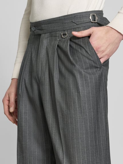 Männermodel trägt Baggy Fit Bundfaltenhose mit Gesäßtasche von RETERNITY, grau mit feinen Streifen, Eingrifftaschen, Nahaufnahme Oberkörper.