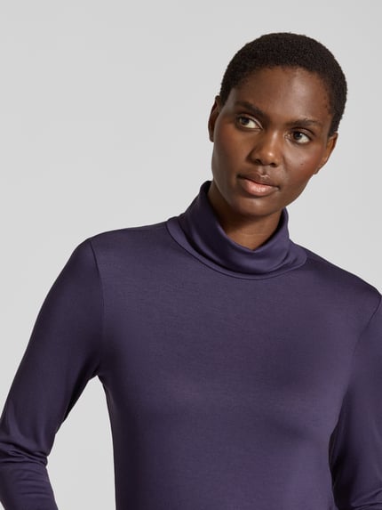 Frauenmodel trägt Slim Fit Longsleeve aus elastischem Viskose-Mix Modell 'Liana' von FREE/QUENT in Dunkellila, Nahaufnahme Oberkörper. Rückenlänge bei Größe S: 53 cm, elastischer Stoff, Rollkragen.