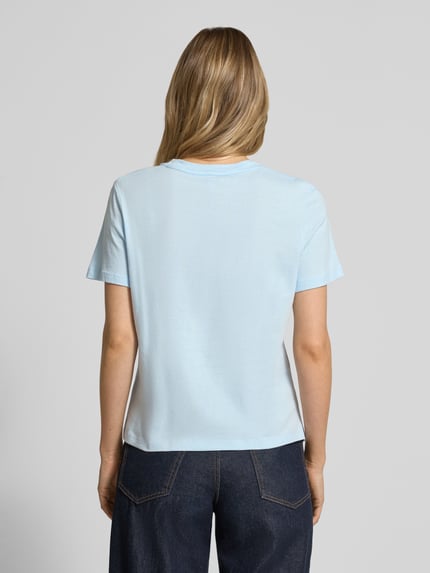 Frauenmodel trägt Regular Fit T-Shirt aus reiner Baumwolle von Tommy Hilfiger, unifarben hellblau, Kurzarm, Jersey, Ganzkörperansicht Rückansicht.