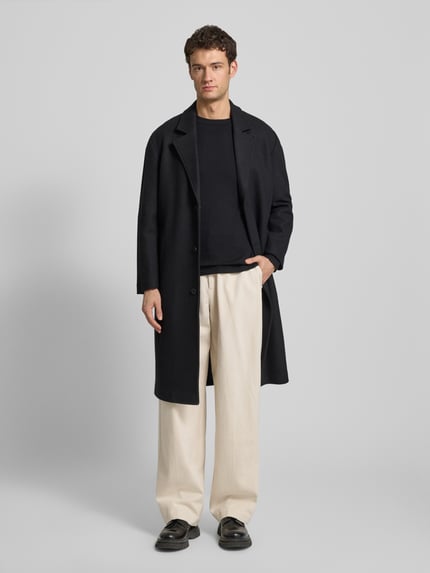 Männermodel trägt Stoffhose mit französischen Eingrifftaschen von Emporio Armani, Reine Baumwolle, Gerader-Schnitt, Cremefarbe, Ganzkörperansicht von vorne.