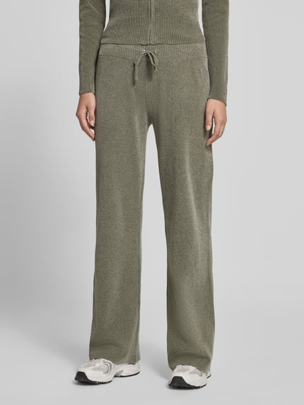 Frauenmodel trägt Sweathose mit Tunnelzug von Juicy Couture, unifarben, mit Kordeln und elastischem Bund, Nahaufnahme Unterkörper.