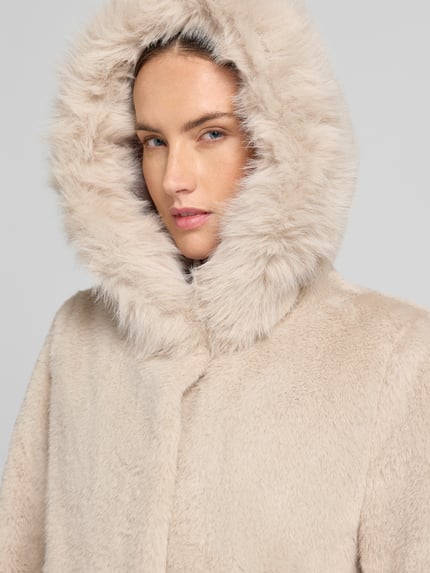 Frauenmodel trägt Mantel aus Kunstfell mit Eingrifftaschen von Marc Cain in Beige, weiche Textur, Nahaufnahme Oberkörper, Regular Fit, Knopfverschluss, KI-modifiziertes Bild, Rückenlänge 90 cm, Schulterbreite 39 cm, Brustweite 55 cm, Ärmellänge 63 cm.