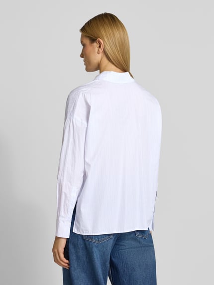 Frauenmodel trägt Relaxed Fit Bluse mit verlängertem Rückenteil Modell 'CLOELIA' von Drykorn, reine Baumwolle, Rückenansicht, Ganzkörperansicht.