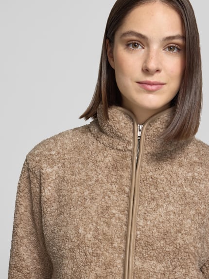 Frauenmodel trägt Teddyjacke mit Stehkragen und Eingrifftaschen von Christian Berg Woman, beige, Teddyfell-Textur, Nahaufnahme Oberkörper.