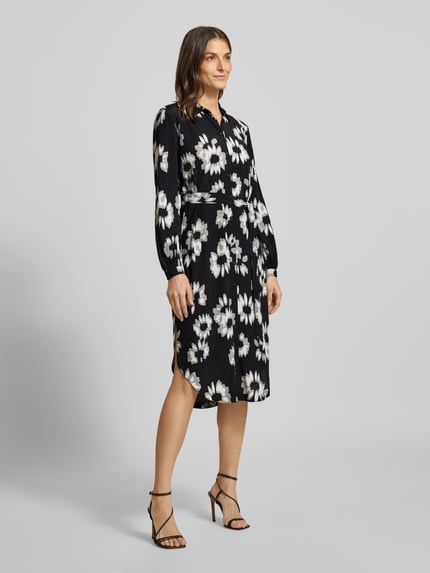 Frauenmodel trägt Midikleid mit Bindegürtel von Esprit, reine Viskose, gerader Schnitt, Umlegekragen, floraler Allover-Print, durchgehende Knopfleiste, Bindegürtel, dunkle Grundfarbe mit weißen und grauen Blumen, Ganzkörperansicht von vorne.
