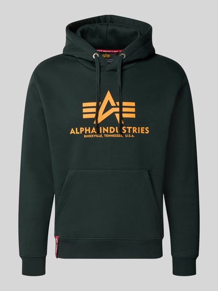 Produktfoto, Regular Fit Hoodie aus Baumwoll-Mix mit Logo-Print von Alpha Industries in Dunkelgrün, orangefarbener Aufdruck, elastische Abschlüsse, Kapuze mit Tunnelzug, langärmlig, Label am Saum