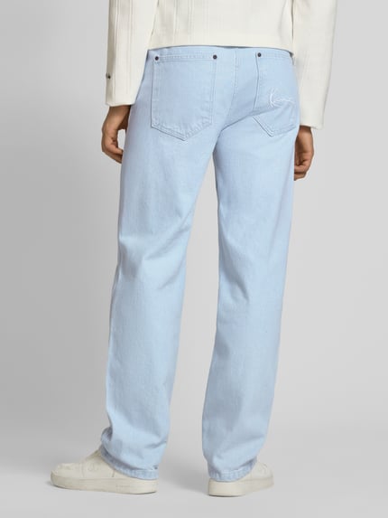 Männermodel trägt Loose Fit Jeans mit Kontrastnähten von KARL KANI in Hellblau, 5-Pocket-Design, Rückansicht, Ganzkörperansicht.