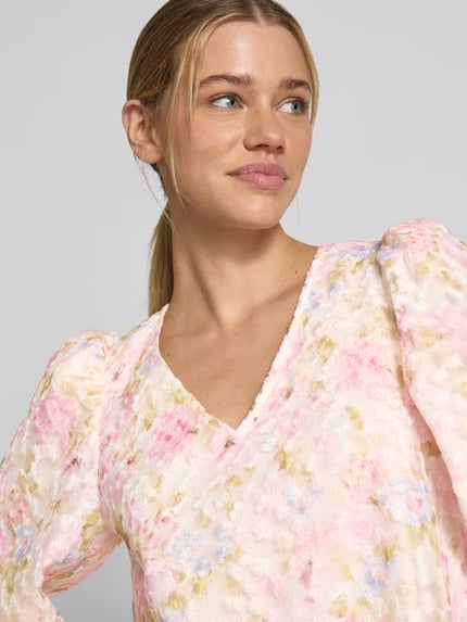Frauenmodel trägt Cocktailkleid mit V-Ausschnitt Modell 'LEANNA' von YAS, florales Muster in Rosa und Beige, 3/4-Arm, Nahaufnahme Oberkörper. Damen Cocktailkleid in A-Linie, Minikleid, Rückenlänge bei Größe 36: 87 cm, Brustweite: 46 cm, Ärmellänge: 48 cm.