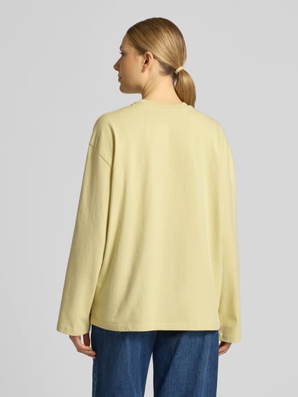 Vrouwenmodel draagt Longsleeve met motiefprint en ronde hals van Topshop, relaxed fit, puur katoen, ruglengte bij maat S 63 cm. Ganzedlichaamsaanzicht achteraan.