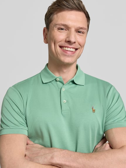 Męski model nosi Regular Fit Poloshirt aus reiner Baumwolle von Polo Ralph Lauren, gładki jasny zielony, krój regular fit, logo na piersi, polokołnierzyk, zapięcie na trzy guziki, krótkie rękawy z ściągaczem, dół z rozcięciem, jersey, czysta bawełna, zbliżenie górnej części ciała.