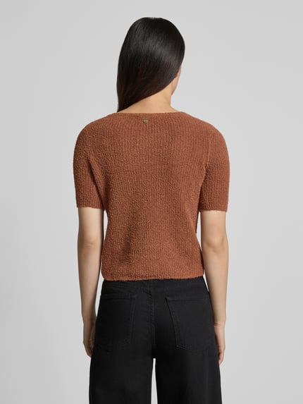 Vrouwenmodel draagt T-Shirt in Strick-Optik mit Rundhalsausschnitt van Rich & Royal in bruin, katoenmix, straight fit, ruglengte 50 cm, mouwlengte 28 cm, detail van textuur, volledige rugaanzicht.