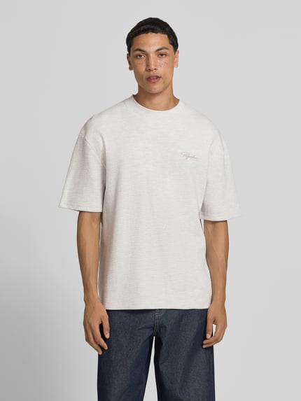Männermodel trägt Oversized T-Shirt mit Strukturmuster und Label-Stitching von Pegador aus Reine Baumwolle, Herren T-Shirt, Ganzkörperansicht von vorne.