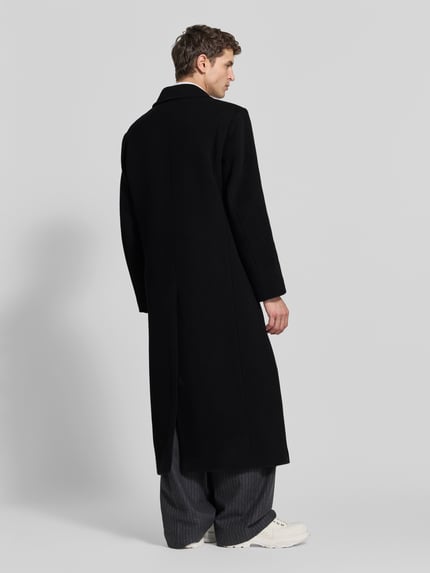 Männermodel trägt Mantel aus Baumwoll-Mix von Filippa K, Schwarz, gerade Passform, doppelreihige Knopfleiste, Pattentaschen, długie rękawy, długość tyłu 135 cm, szerokość ramion 48 cm, długość rękawów 67 cm, Ganzkörperansicht Rückansicht