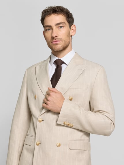 Männermodel trägt Regular Fit Sakko mit Pattentaschen und Reverskragen von MCNEAL im hellen Material-Mix mit Leinen-Anteil, Nahaufnahme Oberkörper.
