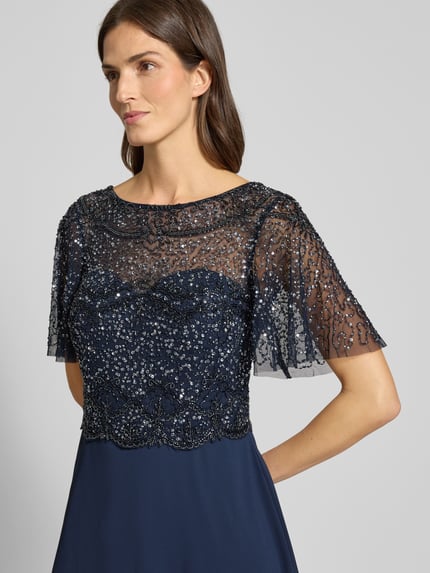 Frauenmodel trägt Abendkleid mit Perlen und Pailletten von Christian Berg Cocktail, A-Linie, Maxikleid, 2-in-1-Look, Nahaufnahme Oberkörper.