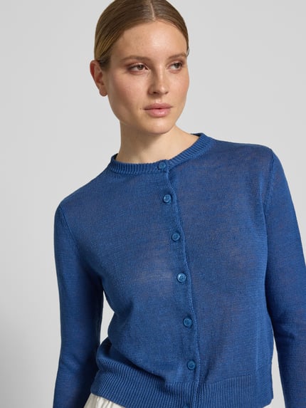Kobiece model prezentuje Regular Fit Strickjacke aus reinem Leinen Modell 'BADIA' od Weekend Max Mara, jednokolorowy niebieski, krój regular fit, okrągły dekolt, długie rękawy, listwa guzikowa, materiał: dzianina z czystego lnu, wykończenie: prążkowane, efekt: jednolity kolor, zbliżenie na górną część ciała.