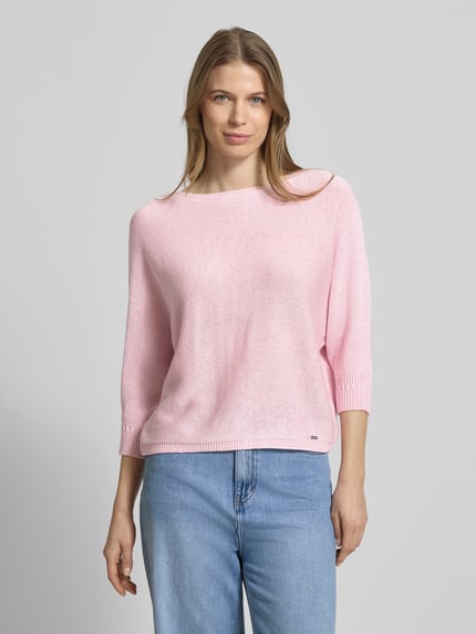 Frauenmodel trägt Strickpullover mit 3/4-Arm von More & More in Rosa, lockerer Schnitt, Rundhalsausschnitt, glatte Textur, Nahaufnahme Oberkörper.