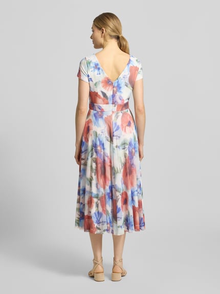 Vrouwenmodel draagt 'Cocktailkleid mit V-Ausschnitt' van Vera Mont, kleurrijke bloemenprint, chiffon, a-lijn, midi, rug rits, rugzijde v-hals, gevoerde onderjurk, achteraanzicht volledige lichaamsopname.