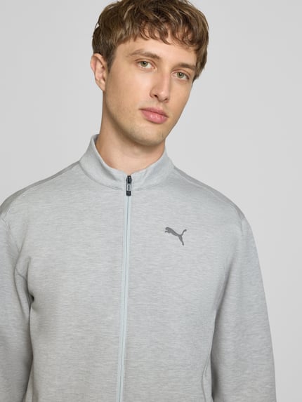 Männermodel trägt Sweatjacke mit Stehkragen und Logo von PUMA PERFORMANCE aus grauem Material-Mix mit Lyocell-Anteil, Nahaufnahme Oberkörper.