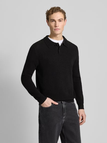 Männermodel trägt Poloshirt mit gerippten Abschlüssen von Forét in Schwarz, Woll-Mix, Regular Fit, Ganzkörperansicht von vorne.