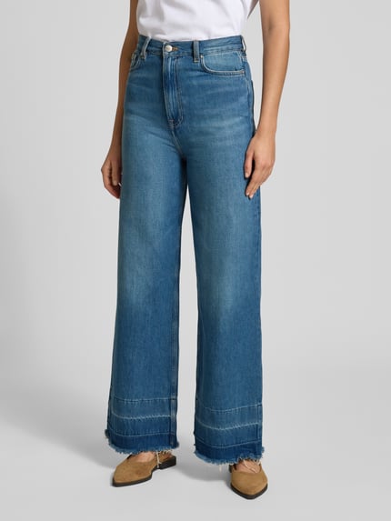 Frauenmodel trägt Flared Cut Jeans mit Fransen Modell 'REBECCA' von Samsøe Samsøe, reine Baumwolle, blaue Denimtextur, Ganzkörperansicht von vorne