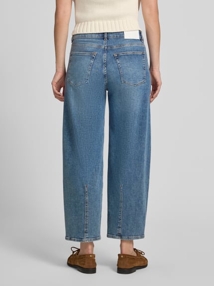 Modelka nosi niebieskie jeansy OPUS PANTS Curved Barrel Jeans aus Baumwoll-Mix Modell 'Meni moon', luźny fason, tekstura denimu, widok całej sylwetki od tyłu.