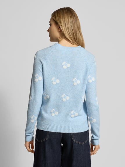 Modelka nosi Regular Fit Strickpullover mit Intarsien Modell 'DOFFY INTARSIA' od Vero Moda, jasnoniebieski sweter z białym wzorem allover, dzianina, krój regular fit, okrągły dekolt, prążkowane wykończenie, widok całych pleców.