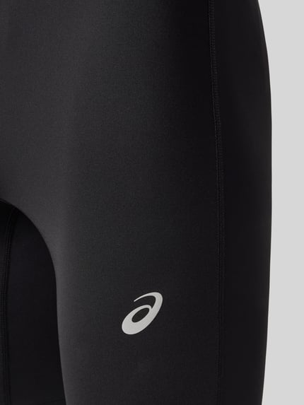 Männermodel trägt Slim Fit Radlerhose mit Logo-Print Modell 'Core' von ASICS TIGER, elastischer Material-Mix, Nahaufnahme Oberschenkel.