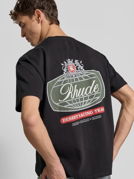 Männermodel trägt T-Shirt mit Label-Print von RHUDE aus reiner Baumwolle in Schwarz, lockerer Schnitt, Rückenansicht, Nahaufnahme Oberkörper.