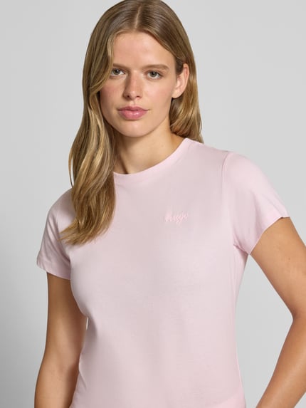 Kobiece modelka nosi różowy Damski t-shirt z krótkim rękawem Regular Fit T-Shirt aus reiner Baumwolle Modell 'Damatee_B' od HUGO Blue, zbliżenie na górną część ciała.
