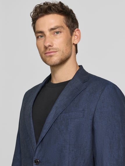 Männermodel trägt Slim Fit 2-Knopf-Sakko aus Leinen Modell 'Hoverest' von JOOP! Collection in Dunkelblau, Nahaufnahme Oberkörper.