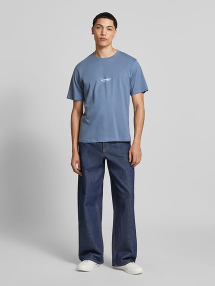 Mannenmodel draagt T-Shirt met Logo en Rundhalsausschnitt van Jack & Jones, blauw, regular fit, bio-katoen, logo op de borst, voorkant volledig lichaam.