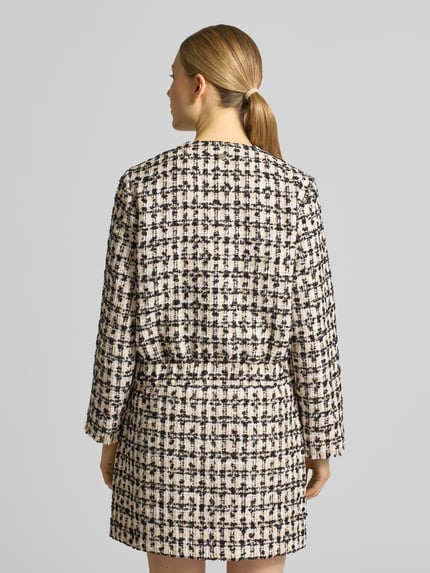 Frauenmodel trägt Regular Fit Blazer in Bouclé-Optik Modell 'Jenifer' von JOOP!, creme-schwarz kariert, Ganzkörperansicht Rückansicht. Rückenlänge 52 cm, Brustweite 49 cm, Ärmellänge 91 cm, aufgesetzte Taschen, durchgängige Knopfleiste, Rundhalsausschnitt.