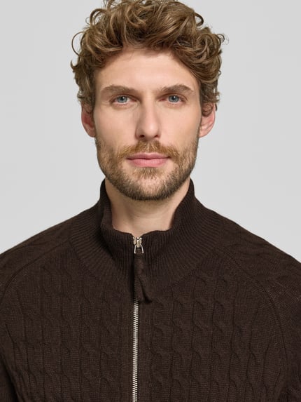Männermodel trägt Regular Fit Strickjacke aus reinem Kaschmir mit Zopfmuster von FTC Cashmere, kolor brązowy, zamek błyskawiczny dwustronny, elastyczne wykończenia, ścieg warkoczowy, Długość tyłu w rozmiarze 50: 70 cm, Długość rękawów w rozmiarze 50: 48 cm, zbliżenie na górną część sylwetki
