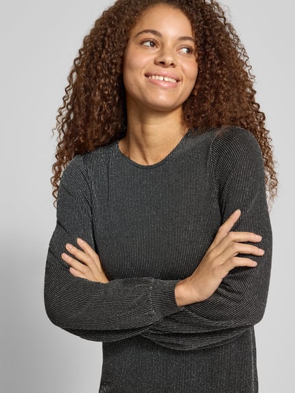 Frauenmodel trägt Langarmshirt mit Glitzerstruktur von ONLY in unifarbener Optik, feine Struktur, elastische Abschlüsse, Nahaufnahme Oberkörper.