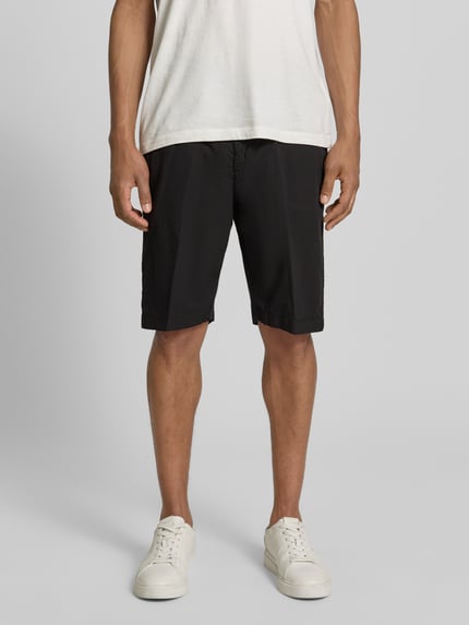 Männermodel trägt Hose mit Gesäßtaschen von MARKUP, schwarze Baumwolle, Regular Fit, sichtbare Gesäßtaschen, Ganzkörperansicht von vorne.