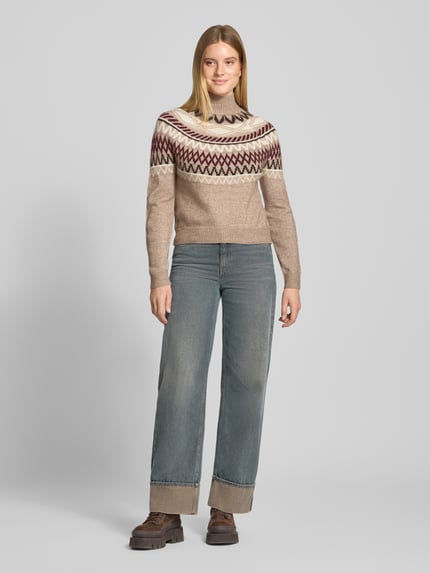 Frauenmodel trägt Pullover mit Jacquardpasse Modell 'VMMAPLE' von VERO MODA, mehrfarbig mit geometrischem Rautenmuster, Strickoptik, hochgeschlossen, langarm, gerippte Abschlüsse, Ganzkörperansicht von vorne.