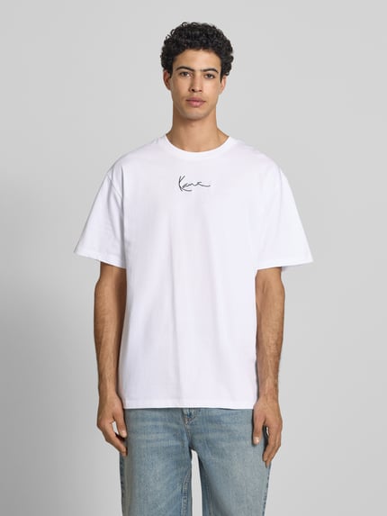 Männermodel trägt Oversized T-Shirt mit Logo-Stitching von KARL KANI, Herren T-Shirt aus Reine Baumwolle, Rundhalsausschnitt, Oversized-Fit, Rückenlänge bei Größe M 72 cm, Ganzkörperansicht von vorne.