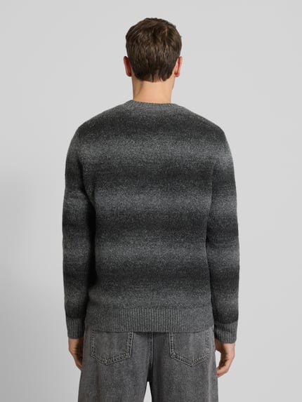 Männermodel trägt Strickpullover mit Rundhalsausschnitt von Jack & Jones Premium, Material-Mix mit Woll-Anteil, lockerer Schnitt, Gerippte-Abschlüsse, Grautöne, Ganzkörperansicht Rückansicht.